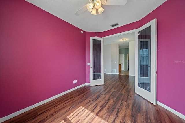 unfurnished room with baseboards, visible vents, wood finished floors, and french doors