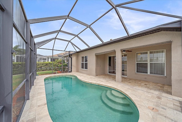 outdoor pool featuring a patio area, glass enclosure, and a ceiling fan