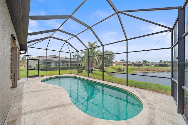 pool with a lanai, a patio area, a water view, and a lawn