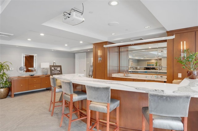 bar featuring visible vents, a raised ceiling, and recessed lighting