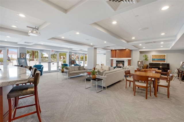 dining room with light carpet, visible vents, a glass covered fireplace, french doors, and recessed lighting