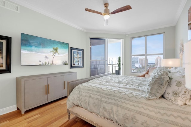 bedroom with access to exterior, crown molding, visible vents, wood finished floors, and baseboards