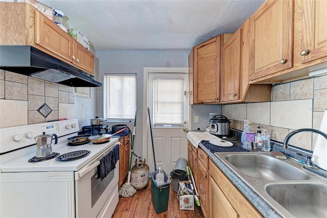 kitchen with electric stove, sink, a textured ceiling, hardwood / wood-style flooring, and decorative backsplash