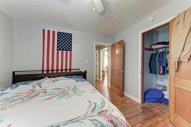 bedroom featuring hardwood / wood-style flooring, ceiling fan, a closet, and a textured ceiling