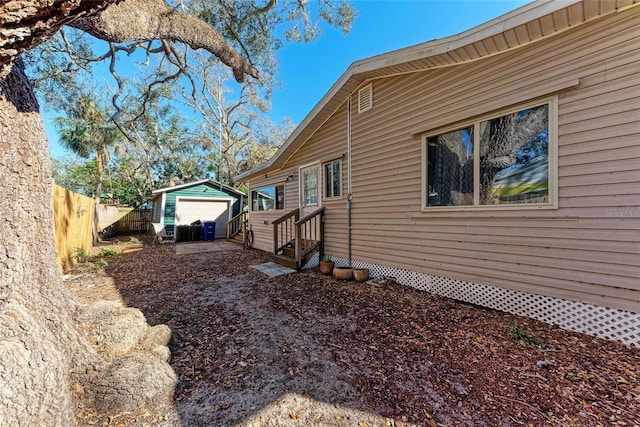 view of side of home featuring a garage and an outbuilding