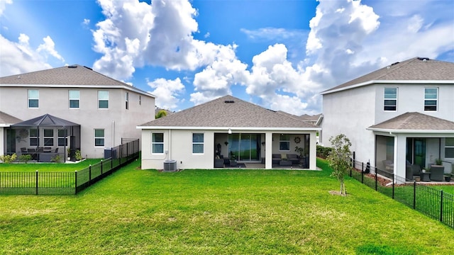 rear view of property featuring a lawn, cooling unit, stucco siding, a sunroom, and a fenced backyard