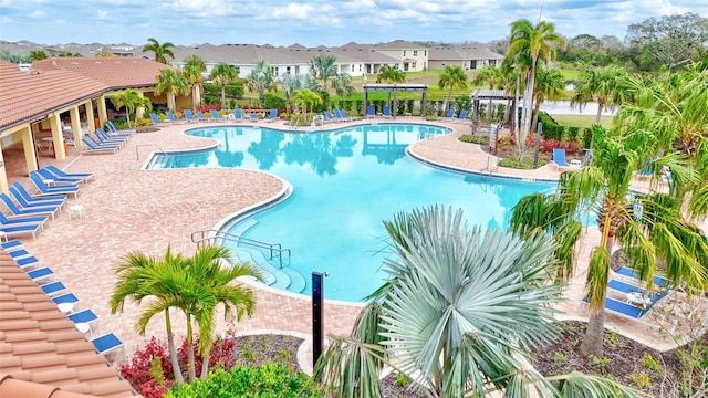 community pool with a pergola, a patio area, and a residential view
