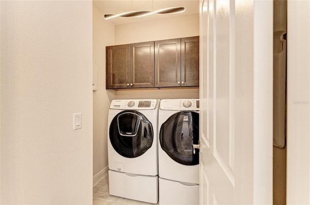 clothes washing area featuring cabinets and independent washer and dryer