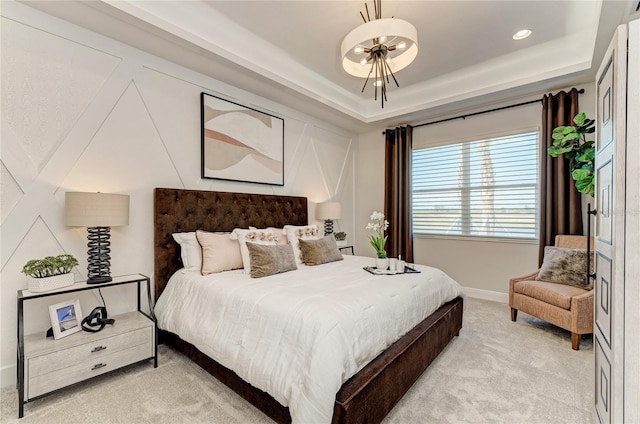 bedroom featuring a raised ceiling and light colored carpet