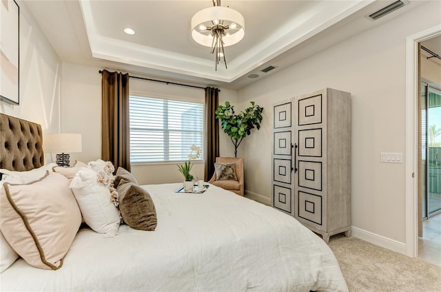 carpeted bedroom featuring a raised ceiling