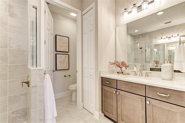 bathroom with vanity, toilet, tile patterned floors, and walk in shower