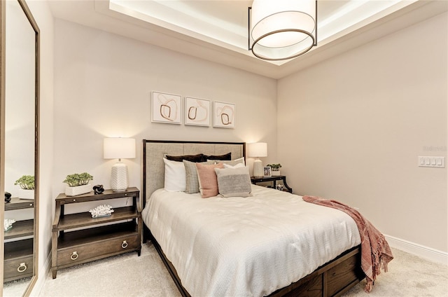 carpeted bedroom featuring a raised ceiling