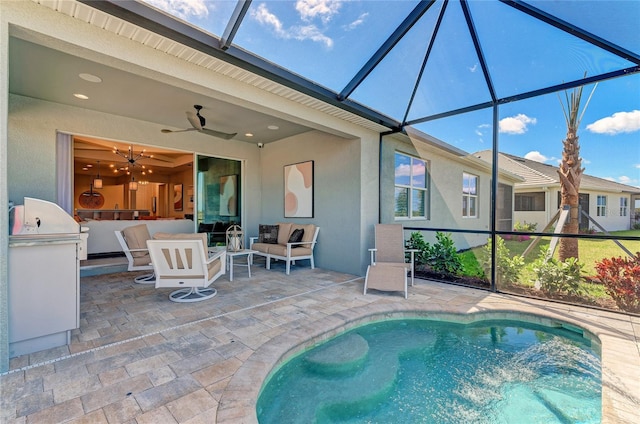 view of swimming pool featuring a patio area, a lanai, an outdoor kitchen, ceiling fan, and outdoor lounge area