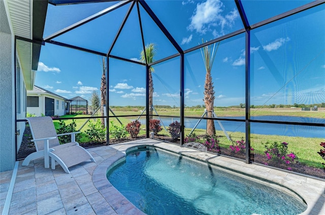 view of pool featuring a patio, a water view, and glass enclosure