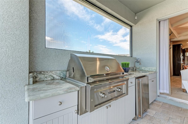 view of patio / terrace featuring area for grilling, sink, and a grill