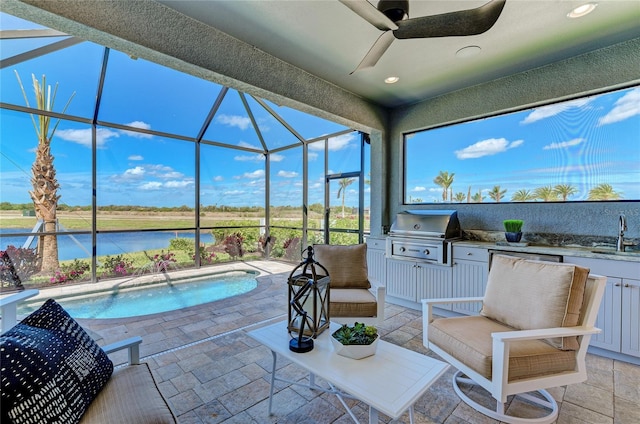 view of pool featuring a water view, pool water feature, ceiling fan, a grill, and area for grilling