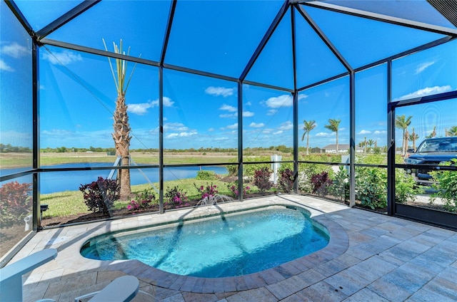 view of swimming pool with glass enclosure, a water view, and a patio area