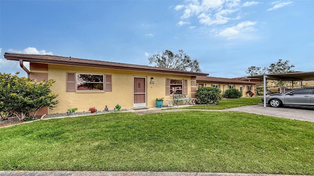 ranch-style house featuring a carport, a front lawn, and stucco siding