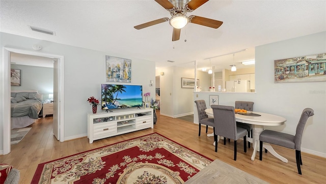 dining room with baseboards, visible vents, ceiling fan, wood finished floors, and a textured ceiling