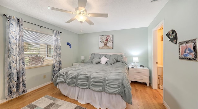 bedroom featuring baseboards, ceiling fan, light wood-style flooring, and a textured ceiling