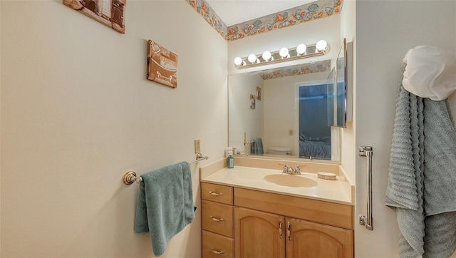 bathroom with ensuite bathroom, toilet, and vanity