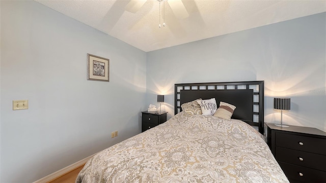 bedroom featuring ceiling fan, baseboards, and wood finished floors