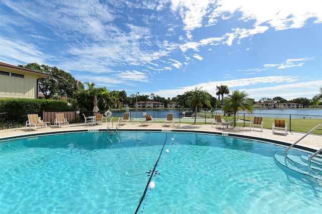 pool with a water view and fence