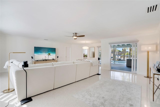 living area with visible vents, crown molding, and ceiling fan