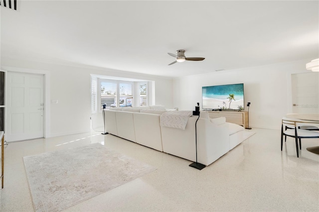 living area featuring ceiling fan, speckled floor, visible vents, and baseboards