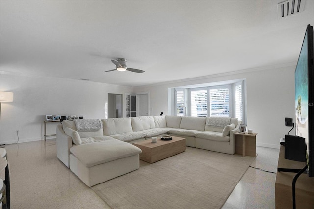 living room with light speckled floor, visible vents, ornamental molding, and baseboards