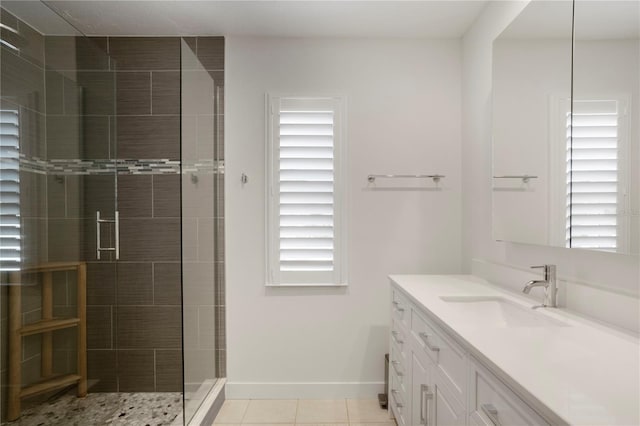 bathroom with a stall shower, vanity, baseboards, and tile patterned floors