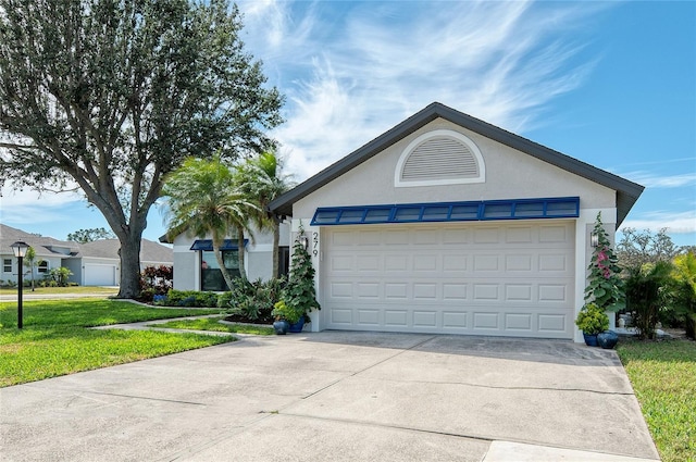 ranch-style house featuring stucco siding, driveway, an attached garage, and a front yard