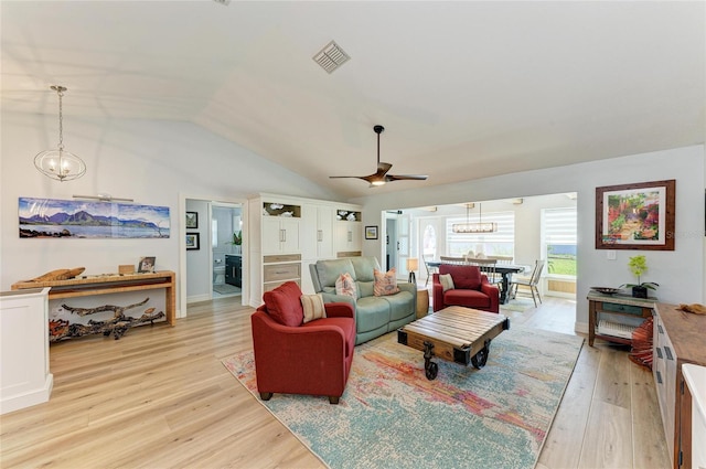 living area with vaulted ceiling, light wood-style flooring, a notable chandelier, and visible vents