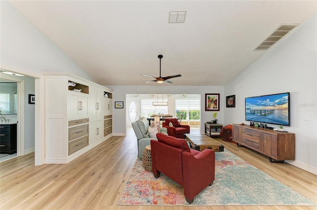 living room featuring high vaulted ceiling, visible vents, and light wood-type flooring