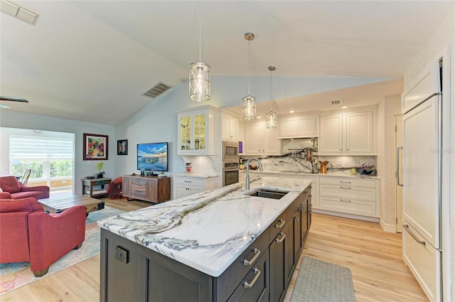 kitchen featuring visible vents, a sink, open floor plan, appliances with stainless steel finishes, and white cabinets