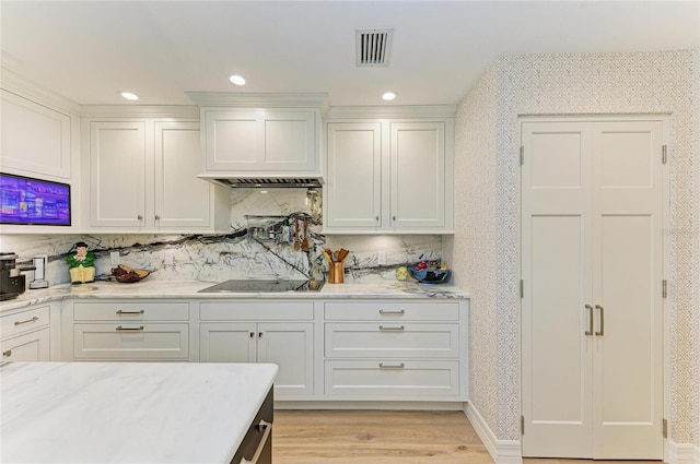 kitchen featuring visible vents, light stone counters, recessed lighting, light wood-style floors, and wallpapered walls