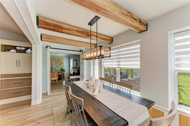 dining area featuring light wood-type flooring, beam ceiling, a notable chandelier, baseboards, and a textured wall