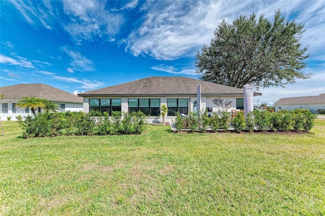 rear view of property with stucco siding and a lawn