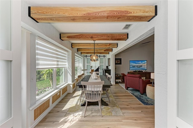 dining space featuring visible vents, beam ceiling, light wood-style floors, and an inviting chandelier