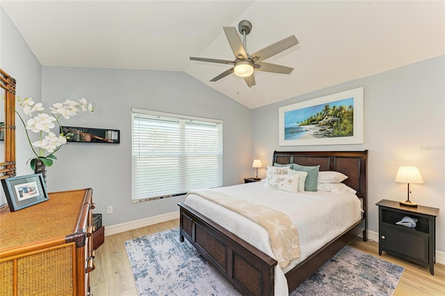 bedroom with a ceiling fan, lofted ceiling, light wood-style floors, and baseboards