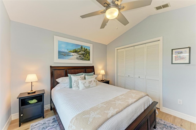 bedroom with visible vents, lofted ceiling, light wood-style flooring, a closet, and baseboards