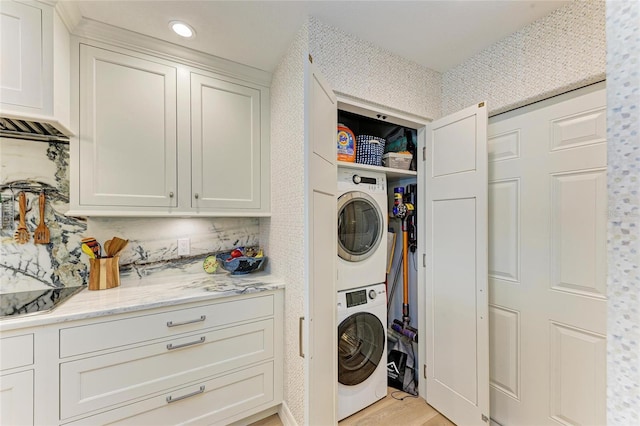 washroom featuring laundry area, recessed lighting, stacked washer / dryer, and light wood-style floors