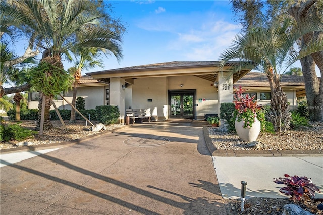 view of front of house with stucco siding and french doors