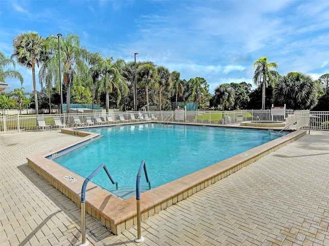 community pool featuring a patio area and fence