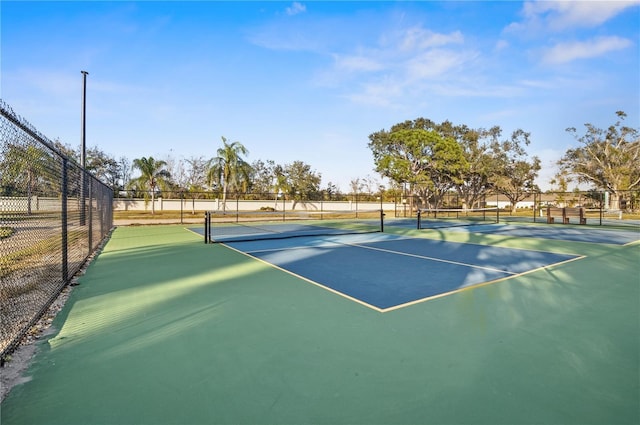 view of tennis court featuring fence