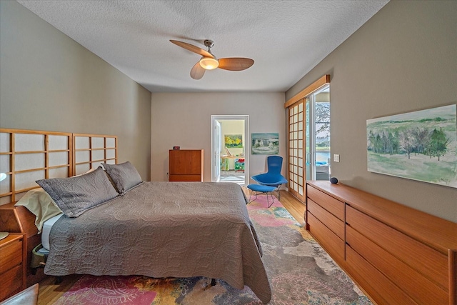 bedroom featuring a textured ceiling, french doors, hardwood / wood-style floors, and ceiling fan