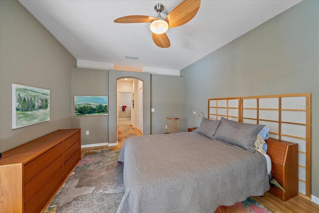 bedroom featuring connected bathroom, ceiling fan, and wood-type flooring