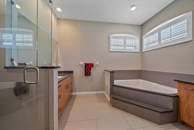 bathroom featuring shower with separate bathtub, tile patterned floors, and vanity