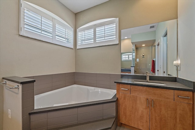 bathroom with vanity and shower with separate bathtub