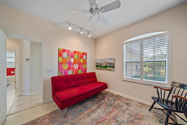 sitting room featuring track lighting, ceiling fan, and tile patterned flooring